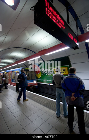 Docklands light Bank Bahnhof Zug Ankunft auf Plattform mit Pendler und Anzeigetafel Stockfoto