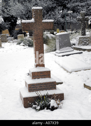 Grab im Schnee bei All Saints Church in Banstead Surrey England Stockfoto