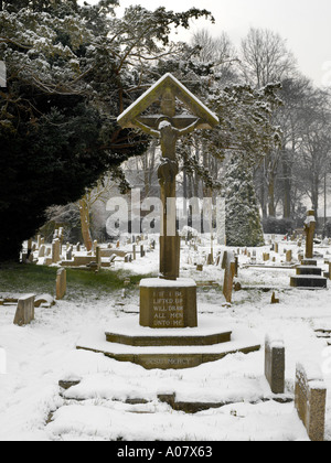 Kruzifix im Schnee bei All Saints Church in Banstead Surrey England Stockfoto