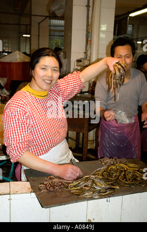 Freundliche chinesische weibliche Aal Verkäufer ihre waren in Suzhou Markt anzeigen Stockfoto