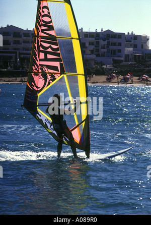 Dh Playa de las Cucharas COSTA TEGUISE LANZAROTE Rosa Gelb segelte unerfahrene Surfer aus üben Strand Lanzarote Windsurfing Stockfoto