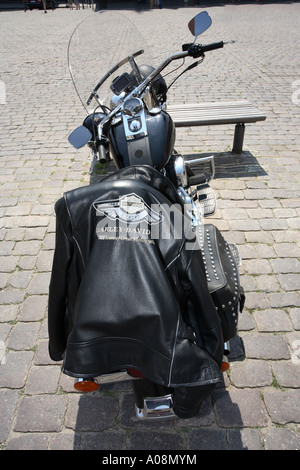 schwarze Lederjacke mit einer Harley Davidson Logo drapiert auf dem Sitz einer Harley Davidson Motorrad Stockfoto