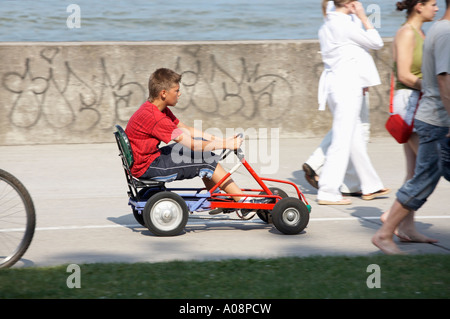 Ein Junge ist eine vier Rädern entlang der Promenade in Gdynia Fahrrad Stockfoto