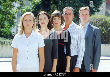 Junge Männer und Frauen stehen hintereinander Stockfoto