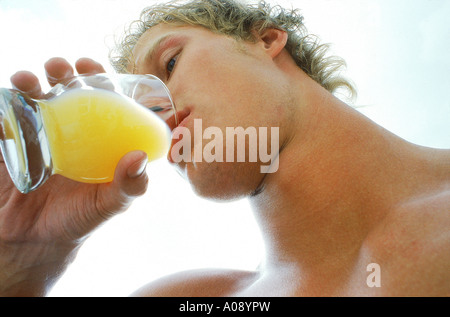 Niedrigen Winkel Blick eines jungen Mannes aus einem Glas Saft zu trinken Stockfoto