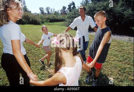 Familie Ring um einen rosigen spielen Stockfoto