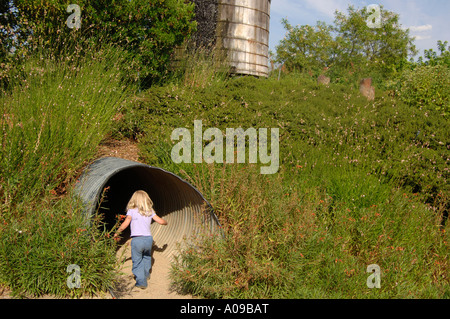 Mädchen erkunden Tunnel, das Solar Living Institut Hopland, Kalifornien, USA Stockfoto