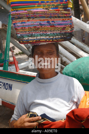 Lächelnden balinesische Frau Sarongs, Padang Bai, Fährhafen nach Lombok, Indonesien Bali zu verkaufen Stockfoto