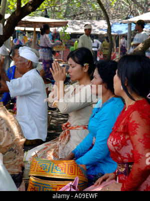 Young balinesische Frau und Familie, die betet an hinduistischen frommen Open-Air-Festivals, Bali Indonesien Stockfoto