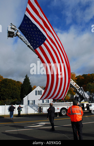 Feuerwehrleute, die eine massive Flagge vor einem Trauerzug für einen gefallenen Polizisten eingerichtet Stockfoto