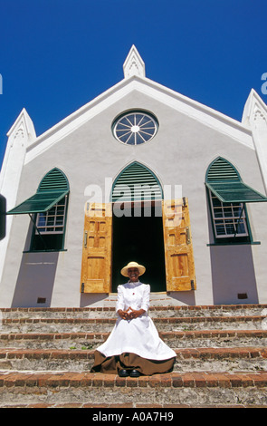 BERMUDA Town of Saint George Woman in historischen Kostümen, sitzen auf den Stufen der St. James Church Stockfoto