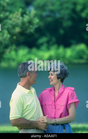 Älteres Paar zu Fuß im Park in der Nähe von einem See Stockfoto