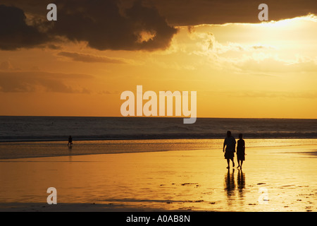 Touristen zu Fuß entlang Legian Beach Stockfoto