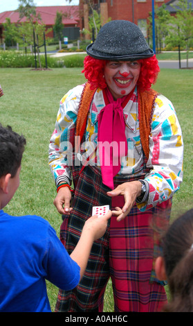 Ein Clown macht einen Kartentrick mit Kindern, Melbourne, Victoria, Australien Stockfoto