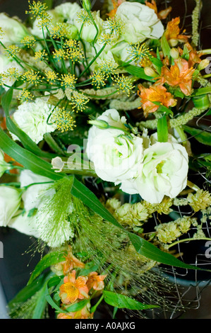 Wunderschönes Arrangement aus rosa weißen Rosen mit grünen Füllstoffen und orangener Alstroemeria in einem professionellen Blumenstrauß-Design. Stockfoto