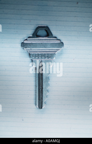 Ein Hausschlüssel liegt auf einer selbstgemachten Papieroberfläche. Stockfoto