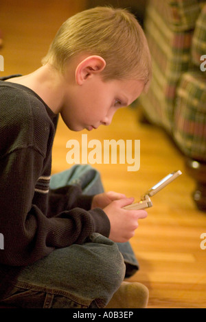 Jungen Alter 7 intensiv spielt Gameboy. St Paul Minnesota MN USA Stockfoto