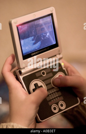 Jungen Alter 7 spielen Nintendo Game Boy mit Daumen. St Paul Minnesota MN USA Stockfoto