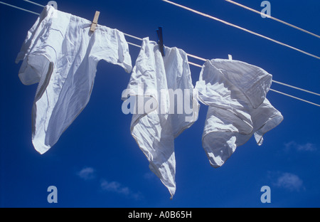 Nahaufnahme von drei weißen Taschentüchern in der Sonne und Wind auf Wäscheleine unter tiefblauem Himmel weht Stockfoto