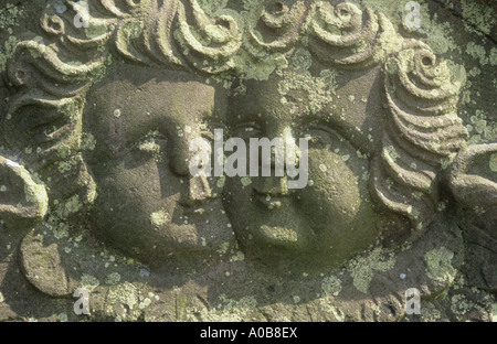 Detail der Flechten bedeckten Grabstein datiert 1833 mit zwei enge Köpfe der cherubic Engel geschnitzt in naiven Stil Stockfoto