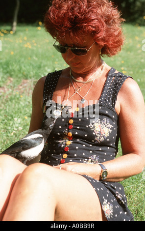 Schwarz-billed Elster (Pica Pica), einziges Tier spielen mit dem Schmuck einer Frau, Deutschland, Rheinland-Pfalz Stockfoto