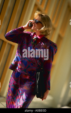 Business-Frau mit Sonnenbrille gehen und sprechen von einem Mobiltelefon Stockfoto