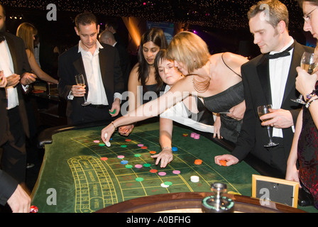 Menschen setzen ihre Chips auf dem grünen Filz von einem Roulette-Tisch im Rahmen einer Firmenveranstaltung England UK Stockfoto