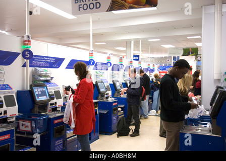 Kunden, die die SB-Kassen-Terminals bei Tesco, England UK Stockfoto