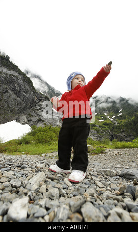 Junge Mädchen stehen im bergigen Geröllfeld mit Rock in Outstreached Hand große vier Trail Cascade Mountains Washington USA Stockfoto