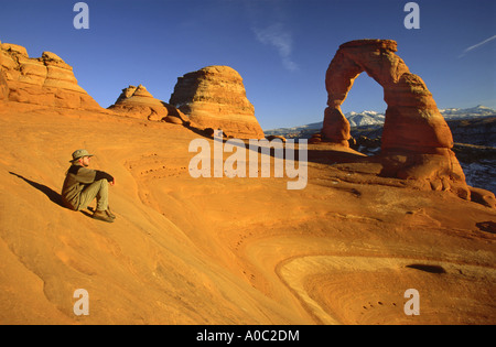 Wanderer in der Nähe von Delicate Arch im Winter, La Sal Mts in Dist, Arches Nat Park, Utah, USA Stockfoto