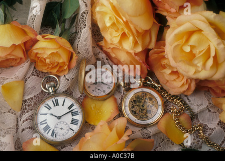 Drei Taschenuhren und gelbe Rosen Stockfoto