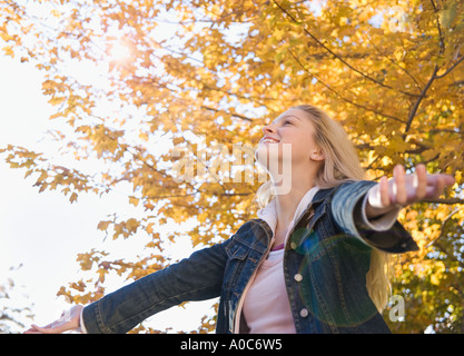 Frau mit ausgestreckten Armen an einem Herbsttag Stockfoto