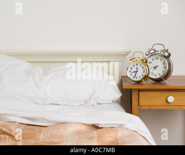 Ungemachten Bett mit Wecker Stockfoto