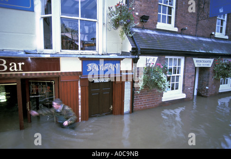 Mann, waten durch Überschwemmungen von Geschäften in Bewdley, nachdem der Fluss Severn seinen Ufern Worcestershire England platzt Stockfoto