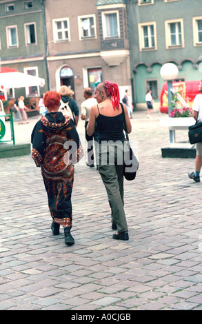 Kostümierte Teens mit Orange gefärbte Haare Alter 18 Fuß Bürgersteig. Poznan Polen Stockfoto