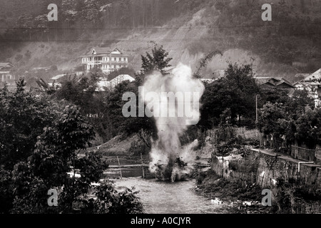 Eine kontrollierte Explosion durchgeführten UXO Lao auf einer Streubombe Einheit in einem Fluss in Sam Neua, Laos Stockfoto