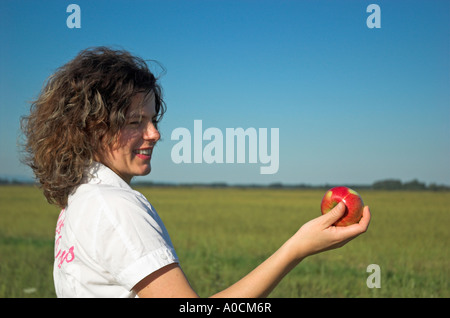 Frau im Freien halten Apfel Stockfoto
