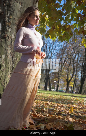 Junge Frau im Park hält Blatt Herbst Stockfoto