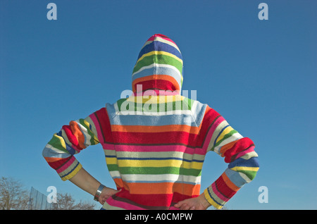 Junge Frau trägt Kapuzensweater stehen im freien Rückansicht Stockfoto