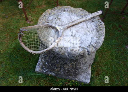 EINE ALTMODISCHE HÖLZERNE GERAHMTE TENNISSCHLÄGER IN EINEM GARTEN-UK Stockfoto