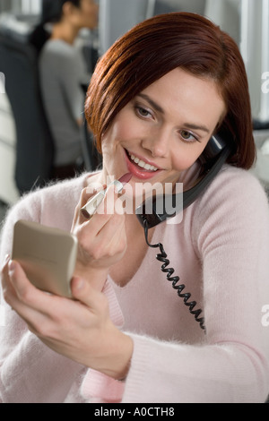 Frau bei der Arbeit auftragen von Lippenstift Stockfoto