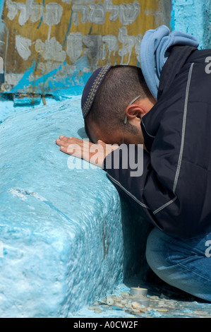 Israel oberen Galiläa Safed Alter Friedhof Nahaufnahme von einem jungen Mann Prosternating auf einem alten blau bemalten Grab Stockfoto