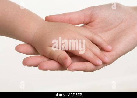 Baby Hand in Hand mit Mutter Stockfoto