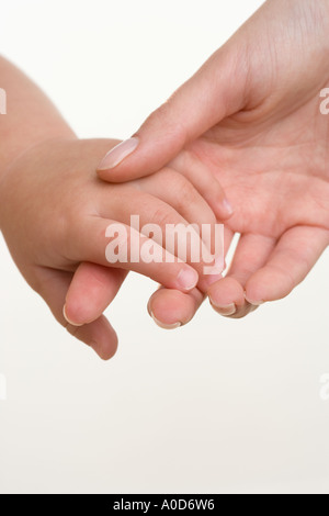 Baby Hand in Hand mit Mutter Stockfoto