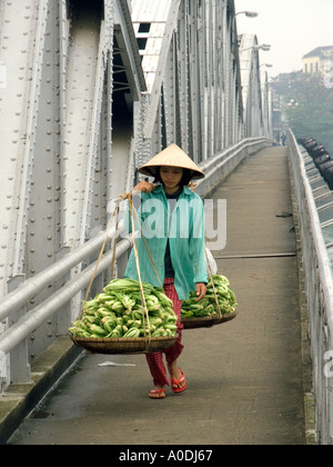 Vietnam Central Hue Trang Tien Brücke über den Parfüm-Fluss Frau mit Gemüse auf Schulter Pol Stockfoto