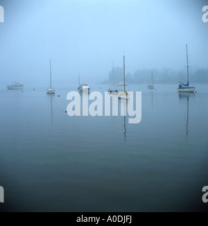 Boote vertäut im frühen Morgennebel, Oulton Broad, Suffolk, England UK Stockfoto