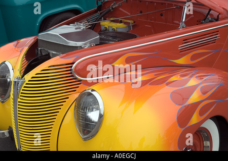 Die vordere Motorhaube eines speziell angefertigten orangen und gelben Ford Hot Rods zeigt lackierte Flammen und einen freiliegenden Motor bei einer Veranstaltung in San Mateo, Kalifornien. Stockfoto