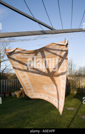 Großes Handtuch hängen zum Trocknen mit Wäscheklammern an rotary Wäscheleine von Wind mit Sonne und blauer Himmel geblasen Stockfoto