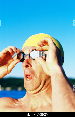 Porträt von männlichen Schwimmer außerhalb Schutzbrille aufsetzen Stockfoto