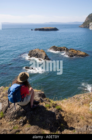 Frau Wanderer sitzen, genießen die Cliftop Blick vom Deception Pass State Park Washington State USA Stockfoto